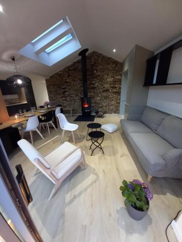 a living room with a couch and chairs and a fireplace at le penty plougonvelin in Plougonvelin