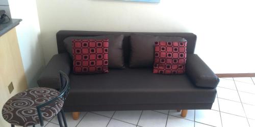 a couch with two pillows on it in a room at Apart Hotel Quartier Latin in Vitória