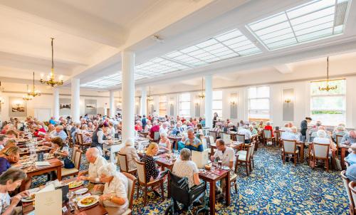 una gran multitud de personas sentadas en mesas en una gran sala en Imperial Hotel, en Eastbourne