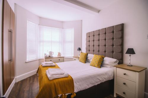 een slaapkamer met een groot bed en een raam bij Haven House Rooms, Barry in Barry