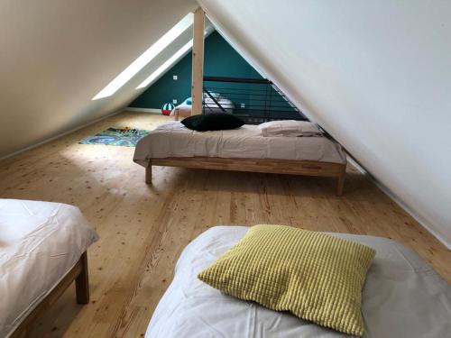 a attic bedroom with two beds and a staircase at le penty plougonvelin in Plougonvelin