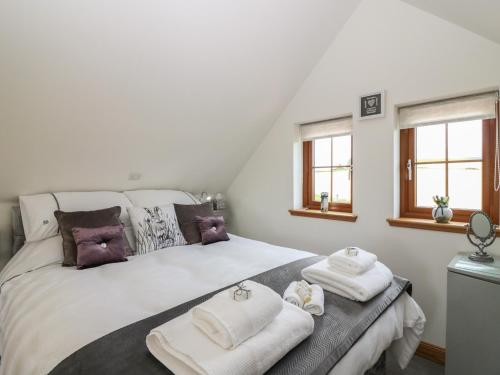 1 dormitorio con 1 cama con toallas en Garden Studio en Insch