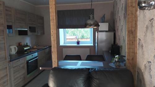 a small kitchen with a table and a refrigerator at Korter kesklinna piirkonnas in Tartu