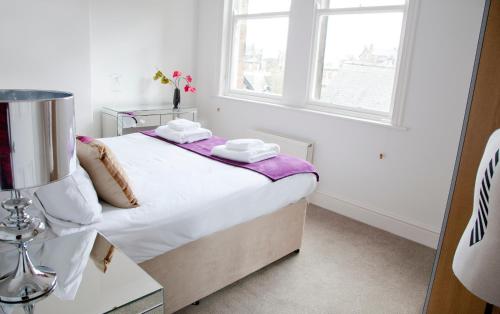 a small white bedroom with a bed and a window at Valley View in Harrogate