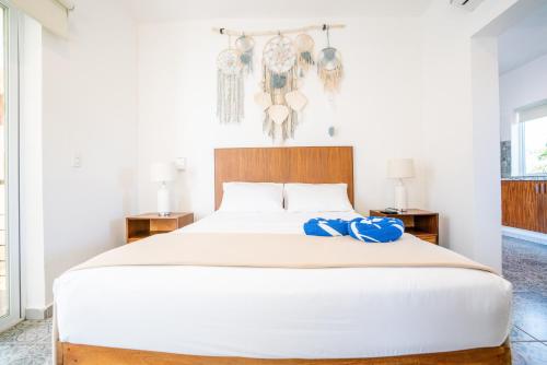 a bedroom with a large white bed with a blue ribbon on it at Viajero Sayulita Hostel in Sayulita