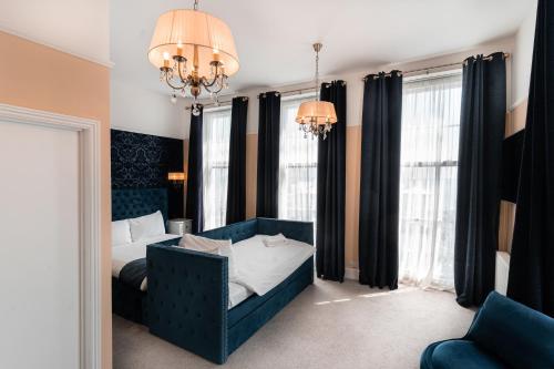 a bedroom with a blue bed and a chandelier at The Pier Hotel in Eastbourne