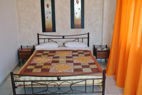 a bedroom with a bed with a quilt on it at Kokalakis Hotel in Kefalos