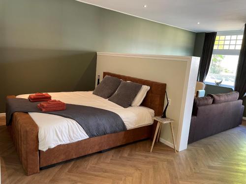 a bedroom with a large bed and a couch at Appartement "Hartje Haamstede" in Burgh Haamstede