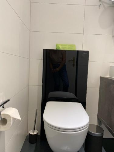 a man standing in a bathroom with a toilet at Boutique City Hotel Gallo in St. Gallen