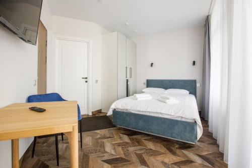 a bedroom with a bed and a wooden table at Seaside Central Hotel in Palanga