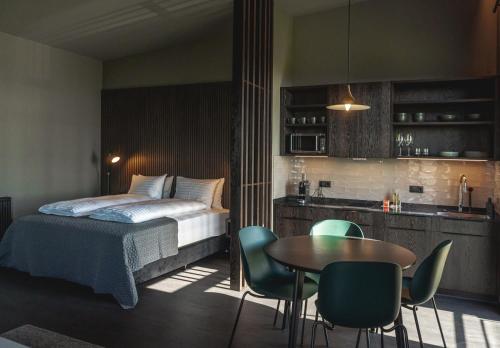 a bedroom with a bed and a table and chairs at Black Beach Suites in Vík