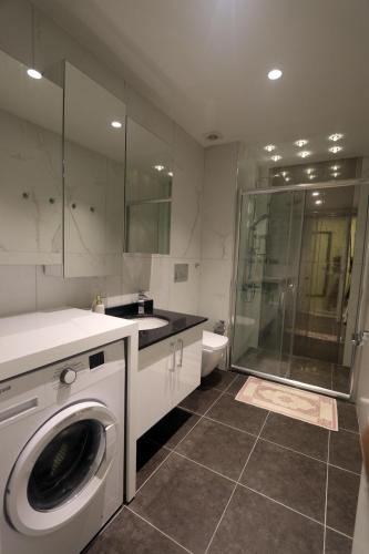 a bathroom with a washing machine and a shower at Апартаменты Best Home 26 Cleopatra Legacy in Alanya