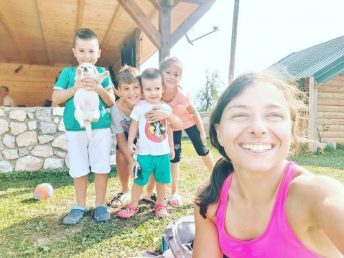 a woman standing next to a group of children at Ethno House Bektesevic in Gusinje
