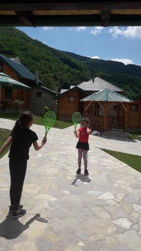 a woman and a young child holding tennis rackets at Ethno House Bektesevic in Gusinje
