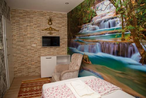 a bedroom with a waterfall mural on the wall at Sinter Terasse House Hotel in Pamukkale
