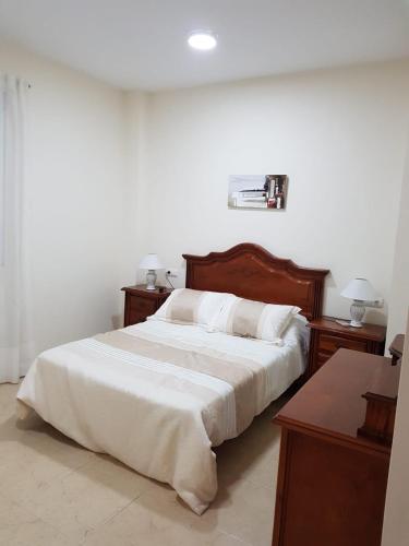 a bedroom with a large bed with white sheets and pillows at Piso en Arcos de la Frontera in Arcos de la Frontera