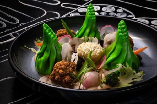 a black plate of food with broccoli and other vegetables at Жилищный комплекс Розмарин in Estosadok