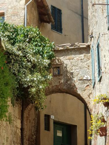 an entrance to a building with an arch in front of it at Dimora in San Quirico d'Orcia in San Quirico dʼOrcia