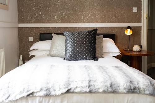 a bedroom with a white bed with pillows at The Cheney Arms in Gaddesby