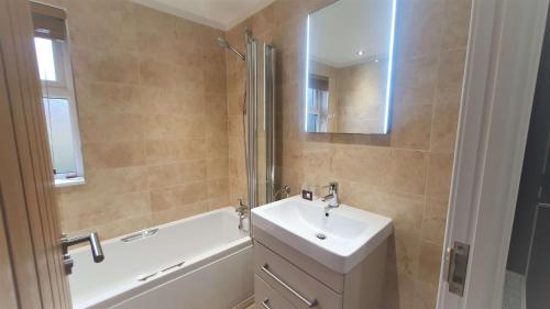 a bathroom with a sink and a bath tub and a mirror at Llyn Alwen Lodge Snowdonia National Park in Betws-y-coed
