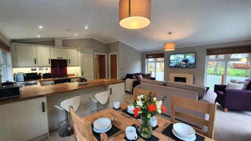 a kitchen and a living room with a table and chairs at Llyn Alwen Lodge Snowdonia National Park in Betws-y-coed