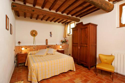 a bedroom with a bed and a cabinet and a chair at Podere Il Pero in Siena