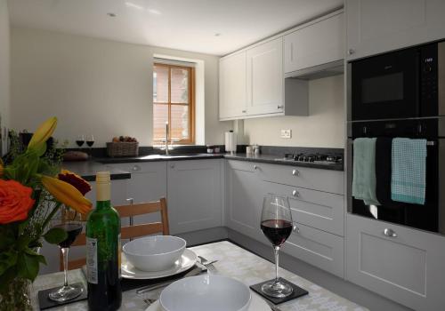 a kitchen with a table with a glass of wine at Tyddyn at Hendre Rhys Gethin in Betws-y-coed