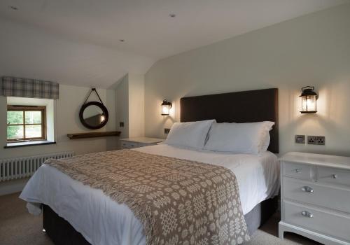 a bedroom with a large bed and a window at Tyddyn at Hendre Rhys Gethin in Betws-y-coed