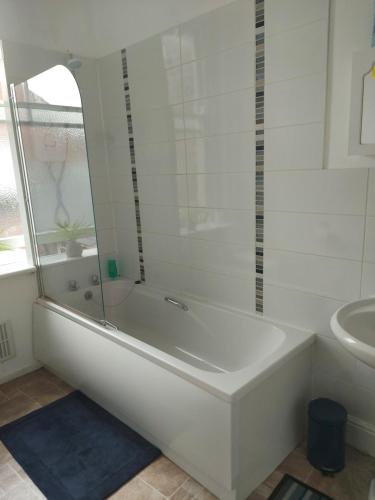 a white bathroom with a tub and a sink at Sandyrise holiday lets in Scarborough