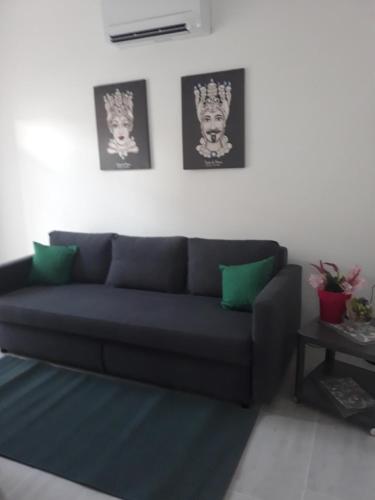 a blue couch in a living room with green pillows at Holiday House Marlin in Giardini Naxos