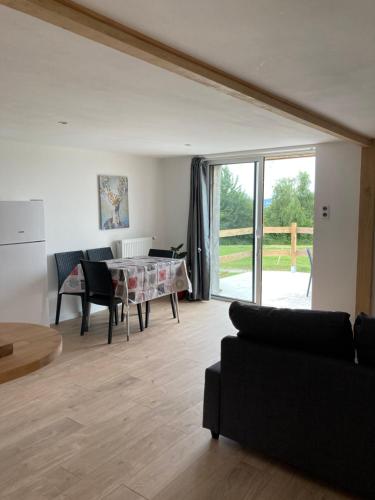 un salon avec une table et un canapé dans l'établissement En Altitude, à Val Couesnon