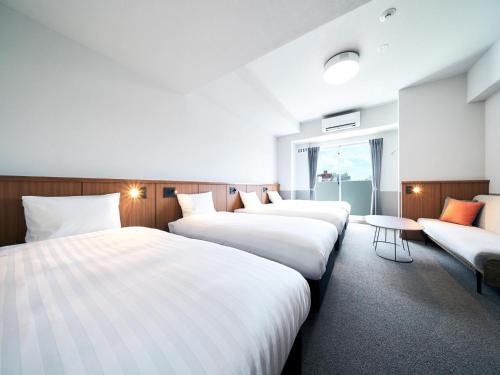 a hotel room with four beds and a couch at Rakuten STAY Naha Yachimun Street - standard 5 Bed Room in Naha