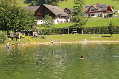 a group of people swimming in a lake at Pernerhof in Aich