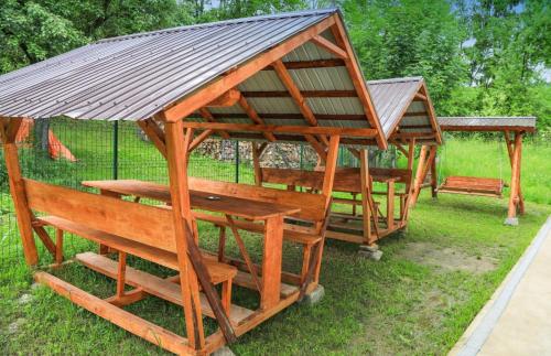 a gazebo with a metal roof and benches at Hățașul Bunicului in Arefu
