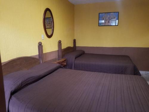 a bedroom with two beds and a mirror on the wall at San Pablo in Pátzcuaro