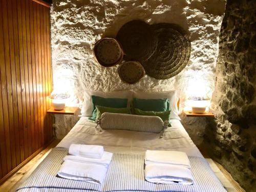 1 dormitorio con 1 cama con toallas en Casa das 5 Cruzes dentro da muralha, en Sortelha