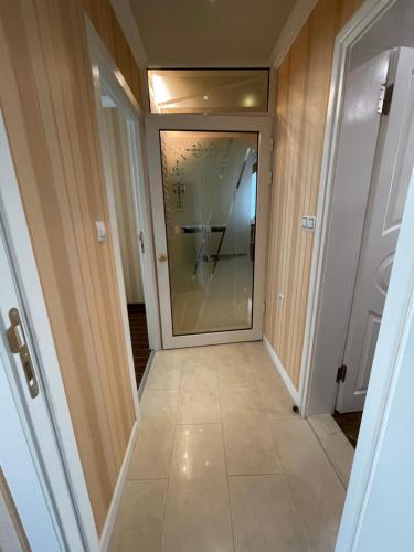 a hallway with a glass door and a tile floor at Apart 47 in Smolyan