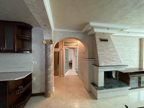 a large kitchen with a fireplace in the middle at Apart 47 in Smolyan