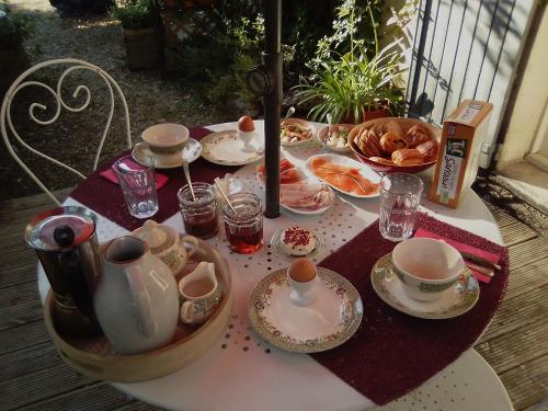 une table avec des assiettes, des tasses et de la vaisselle dans l'établissement Le Domaine de Belle, à LʼIsle-sur-la-Sorgue