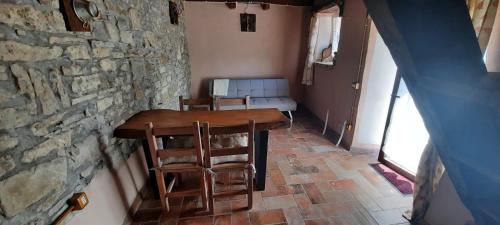 a room with a table and chairs and a stone wall at la corte dei cerri in Spervara