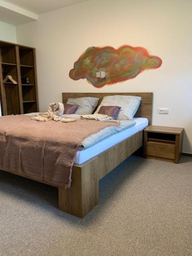 a bedroom with a bed with a large painting on the wall at Kamrovec in Tachov