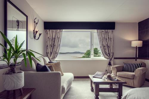 a living room with a couch and a large window at Ardagh Hotel & Restaurant in Clifden