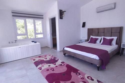 a bedroom with a large bed and a bath tub at muda apart kalkan in Kalkan