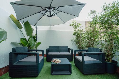 a patio with chairs and an umbrella and a table at Appartements - Centre Ville in Rabat