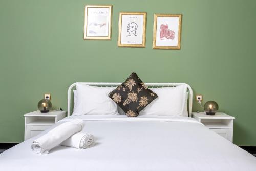 a bedroom with a white bed with three pictures on the wall at Appartements - Centre Ville in Rabat
