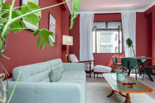 a living room with a blue couch and red walls at Appartements - Centre Ville in Rabat