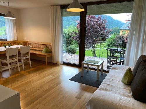 a living room with a couch and a table and a large window at Haus Christiane in Schoppernau