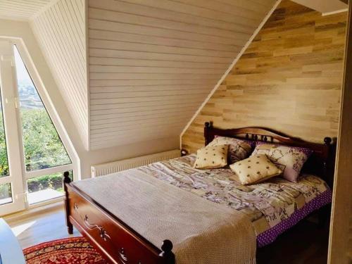 a bedroom with a bed with a wooden wall at Conacul Mierii in Străşeni