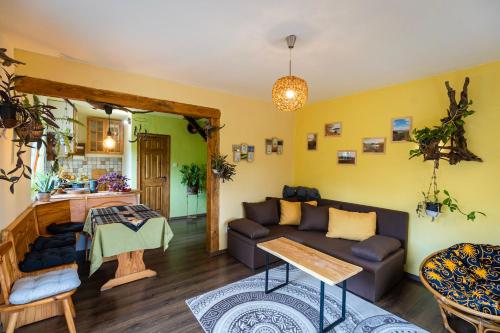 - un salon avec un canapé et une table dans l'établissement FAnima vendégház, à Kismaros