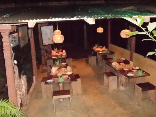 a dining room with tables and chairs and lights at 360 Rainforest in Deniyaya
